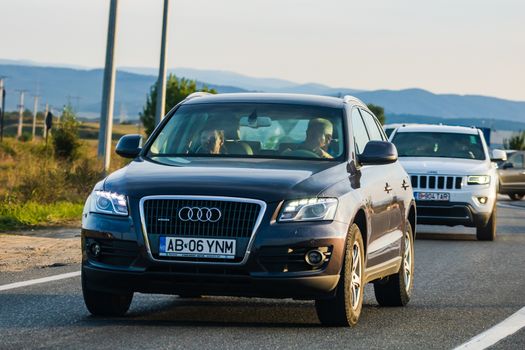 Traveling cars in motion on asphalt road, front view of cars in row on street. Bucharest, Romania, 2020