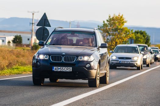 Traveling cars in motion on asphalt road, front view of cars in row on street. Bucharest, Romania, 2020