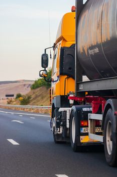 Side view of loaded European truck in motion on asphalt road, transportation and delivery concept. Detail on delivery truck. Bucharest, Romania, 2020