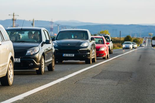 Traveling cars in motion on asphalt road, front view of cars in row on street. Bucharest, Romania, 2020