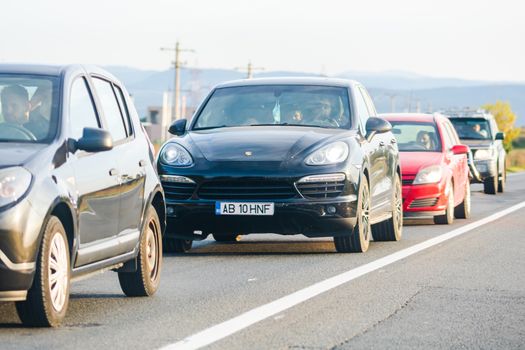 Traveling cars in motion on asphalt road, front view of cars in row on street. Bucharest, Romania, 2020