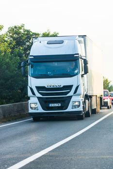 Loaded European truck in motion on asphalt road, transportation and delivery concept. Bucharest, Romania, 2020