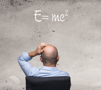 a man reading the relativity formula written on a wall
