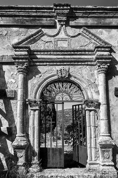 Gate of the destroyed Orthodox church of Agios Spyridon on the island of Kefalonia in Greece, monochrome