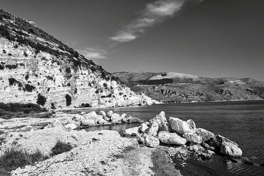 Rocky cliff and boulders in Paliki Bay on the island of Kefalonia in Greece, monochrome