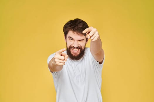 Bearded man on emotions white t-shirt fun lifestyle yellow background. High quality photo