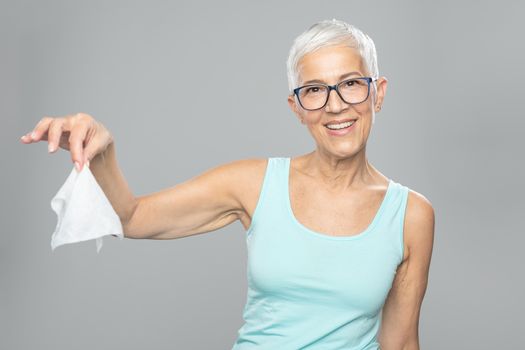 Senior woman cleaning hands and dropping wet wipes - care for health and prevention of infectious diseases stock photo