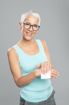Senior woman cleaning hands with wet wipes - care for health and prevention of infectious diseases stock photo