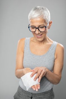 Senior woman cleaning hands with wet wipes, prevention of infectious diseases, covid19