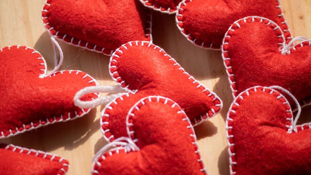 Set of Red felt hearts on a wooden table, romantic handcrafts for Valentine's day close up.