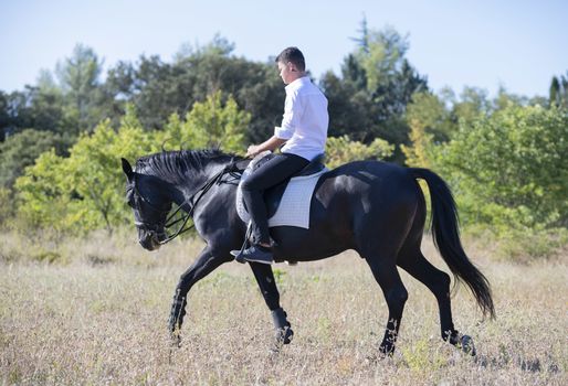  riding teenager are training her black horse