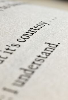 The sentence " courtesy " on a book page ,  studio shot , macro photography