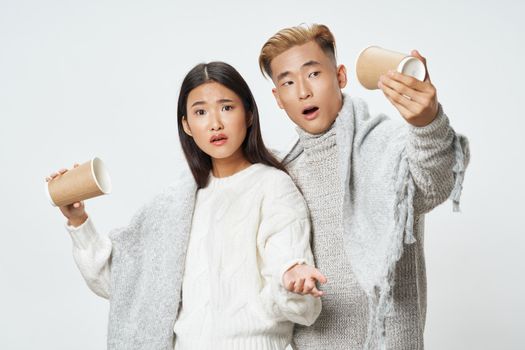 A man and a woman with empty glasses in their hands are cool, covered with a blanket