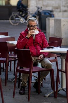 terni,italy november 06 2020:man sitting at a table eats a piece of pizza