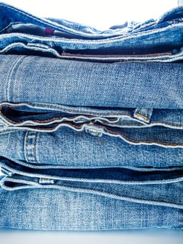 Pile of different blue jeans, fabric texture