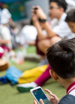 BANGKOK THAILAND - April 19,2018 Many Serious children playing on smartphone, Children playing on smartphone during the brake time in school 