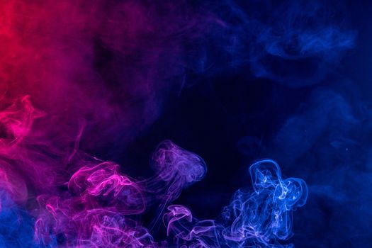 Conceptual image of colorful red and blue color smoke isolated on dark black background, Halloween concept design element.