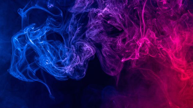 Conceptual image of colorful red and blue color smoke isolated on dark black background, Halloween concept design element.