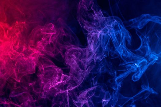 Conceptual image of colorful red and blue color smoke isolated on dark black background, Halloween concept design element.