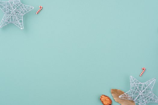 Top view of Christmas holiday decoration ornament composition with Christmas tree, gift star, gingerbread man flat lay with copy space isolated on green background.