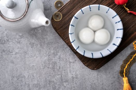 Top view of big tangyuan yuanxiao (yuan xiao tang yuan, glutinous rice dumpling balls) in a bowl on gray background for lunar new year festival food with copy space.