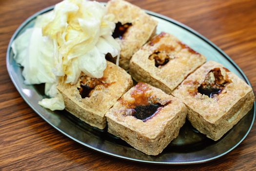 Deep fried stinky tofu, fermented bean curd with pickled cabbage vegetable, famous and delicious street food in Taiwan, lifestyle.