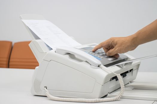 hand man are using a fax machine in the office, equipment for data transmission.