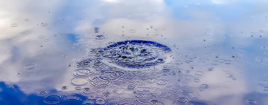 Beautiful water at a lake with splashing water and ripples on the surface with clouds and sky reflections