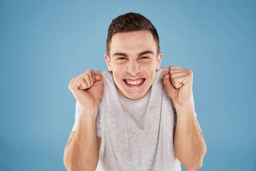 Emotional man in white t-shirt cropped view on blue background lifestyle. High quality photo