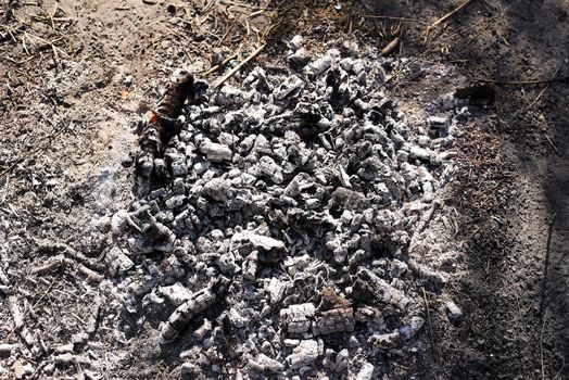 Embers and ashes after a bonfire, destruction, gray