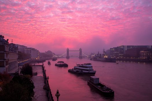 Vibrant, dramatic altocumulus sunrise clouds and fog above Tower Bridge and the River Thames in London, England