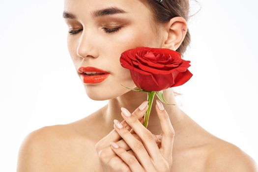 charming brunette girl with makeup on her face and a red rose in her hand. High quality photo