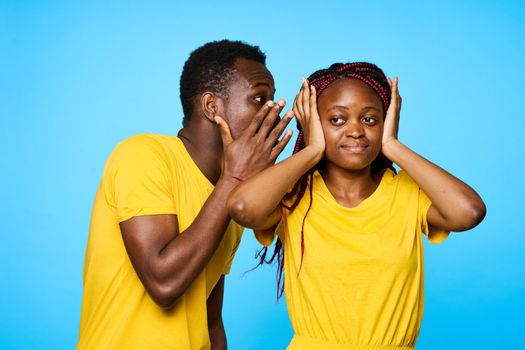 Man and woman in yellow T-shirts African appearance communication dating blue background