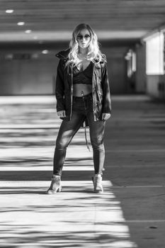 A gorgeous blonde model poses in a parking deck on an autumn day