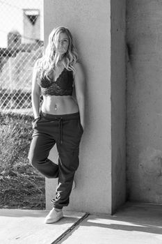 A gorgeous blonde model poses in a parking deck on an autumn day