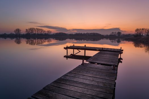 Wooden pier on a calm lake, view after sunset, Stankow, Poland