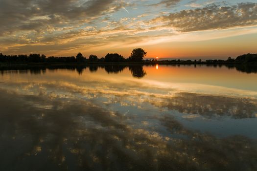Reflection of clouds in a calm lake, view during sunset, Stankow, Poland