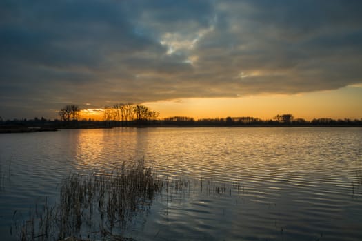 Cloud and sunset over a calm lake with reeds, Stankow, eastern Poland