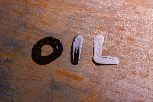 handwritten word oil on rusted sheet metal surface - close-up with selective focus conceptual photography
