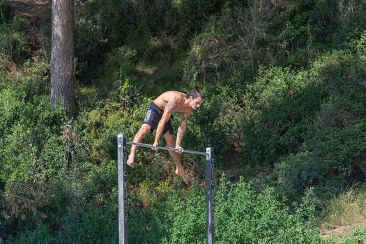 Spain, Tenerife - 09/15/2016: Young man exercising on a horizontal bar. Stock photography