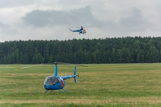 Belarus, Minsk - 07/25/2018: The helicopter is on the field of the airfield and the second helicopter comes in for landing. Stock photography
