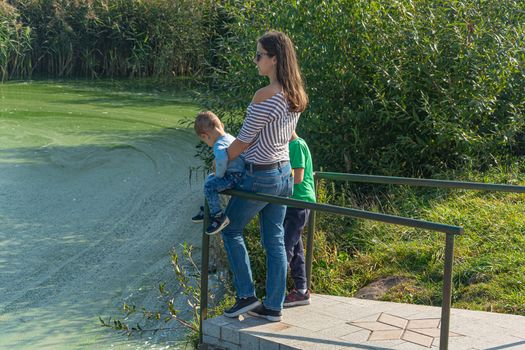 Belarus, Minsk - 09/12/2019: Woman with children on the shore of the reservoir