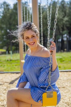 A pregnant blonde model poses for images in an outdoor environment