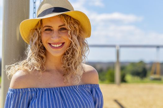 A pregnant blonde model poses for images in an outdoor environment