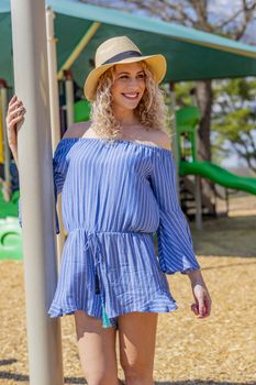 A pregnant blonde model poses for images in an outdoor environment