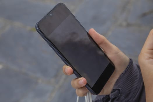 The hand of a young woman, holds a smart mobile phone, Spain.