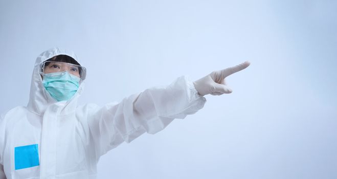 Asia woman doctor in PPE suit or Personal Protective Equipment uniform and wearing medical face mask, rubber gloves and goggles for protect coronavirus pandemic. Studio shot with copy space.