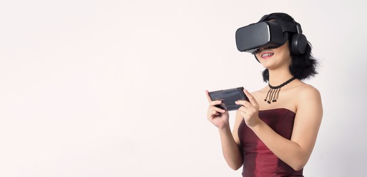 Asian teen woman wearing VR or Virtual Reality head set for enter to the digital simulation world for learning and traveling or gaming  and more. Studio shot white background