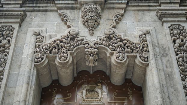 Picture of a sculpted arch over the entrance of a building with byzantine architecture