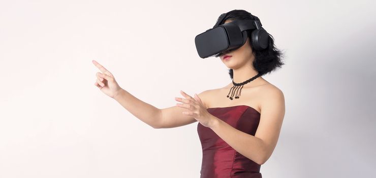 Asian teen woman wearing VR or Virtual Reality head set for enter to the digital simulation world for learning and traveling or gaming  and more. Studio shot white background